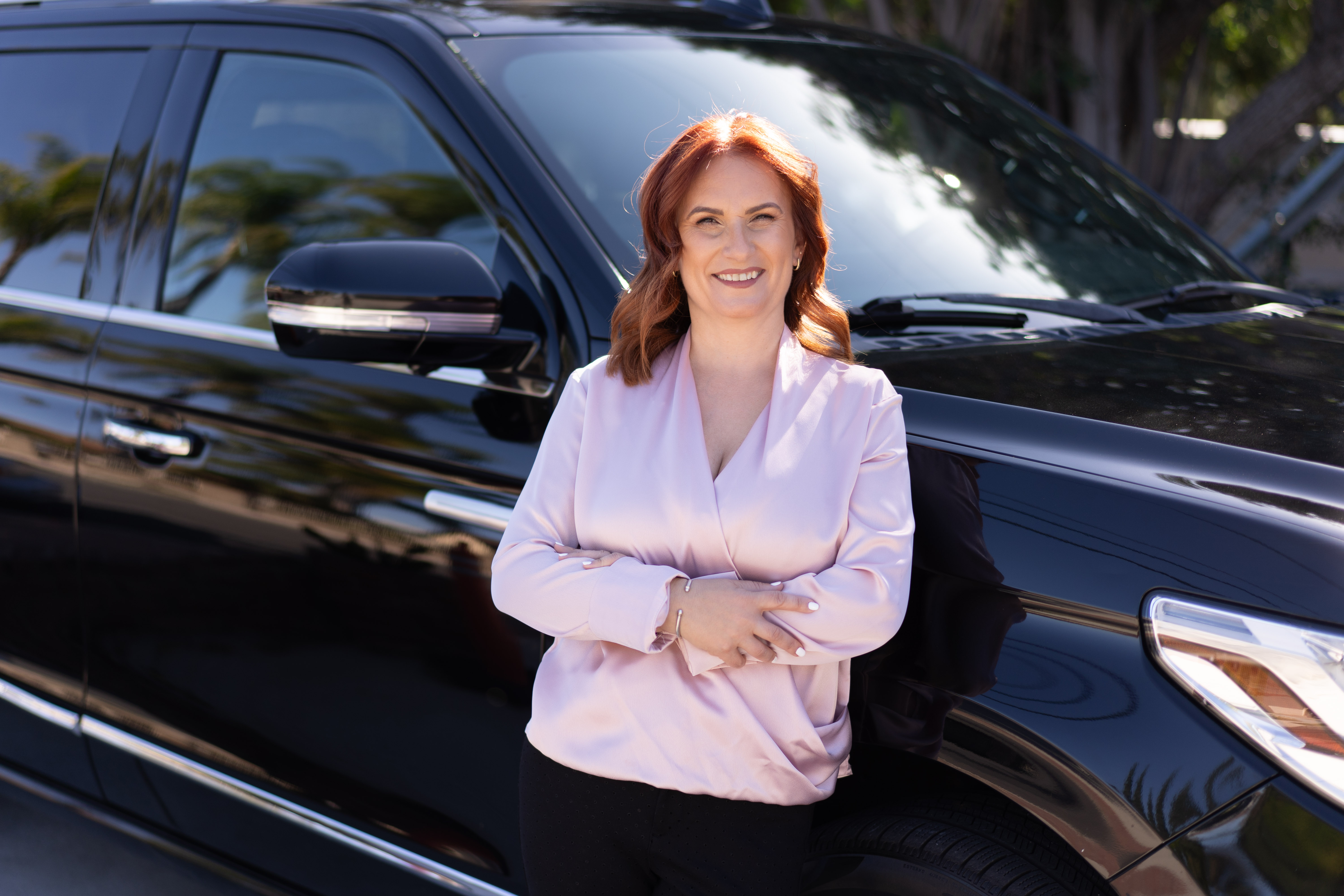 Alina Wade standing beside a Global Limousine Network vehicle